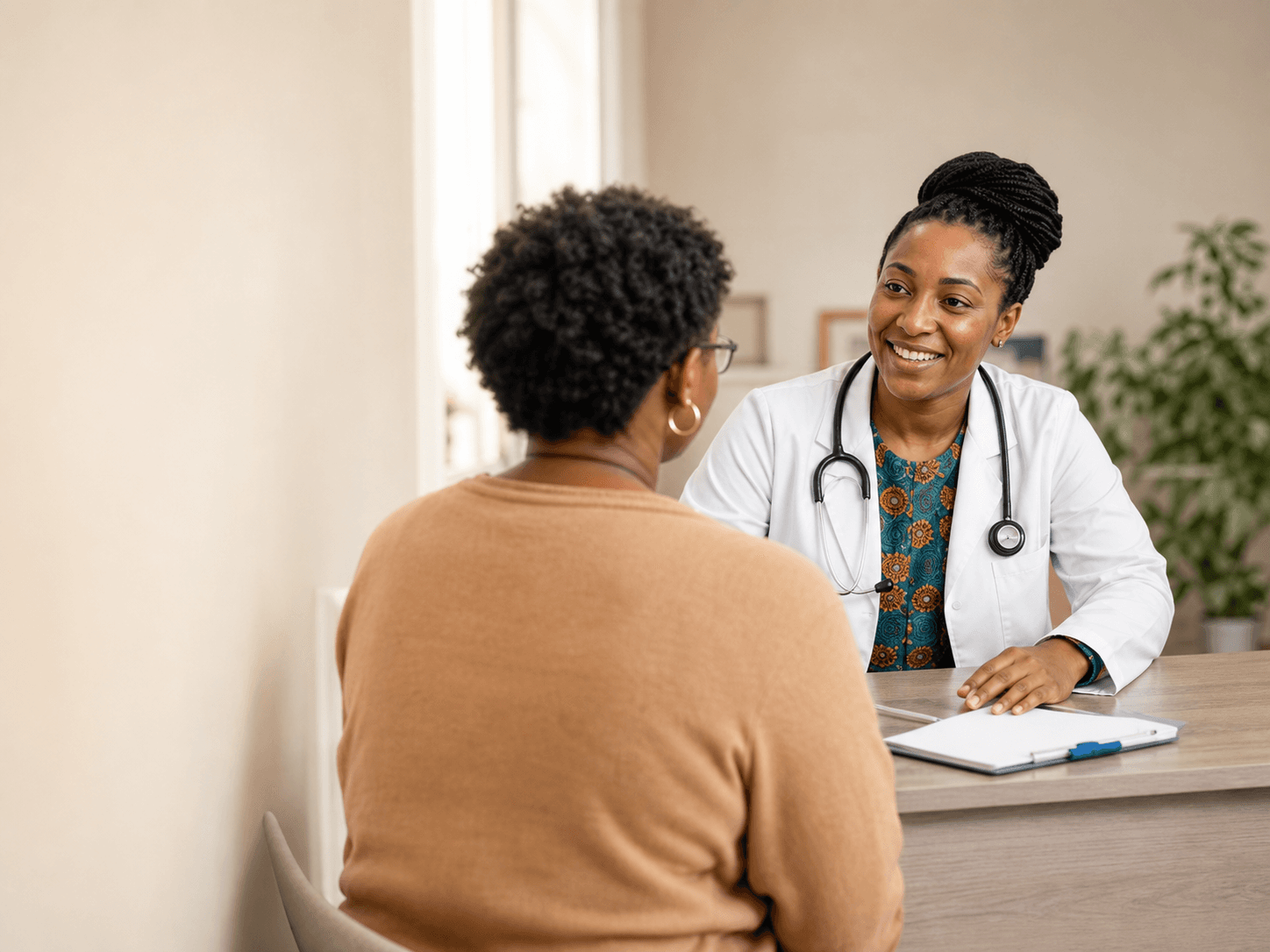 A Black physician speaking with a patient