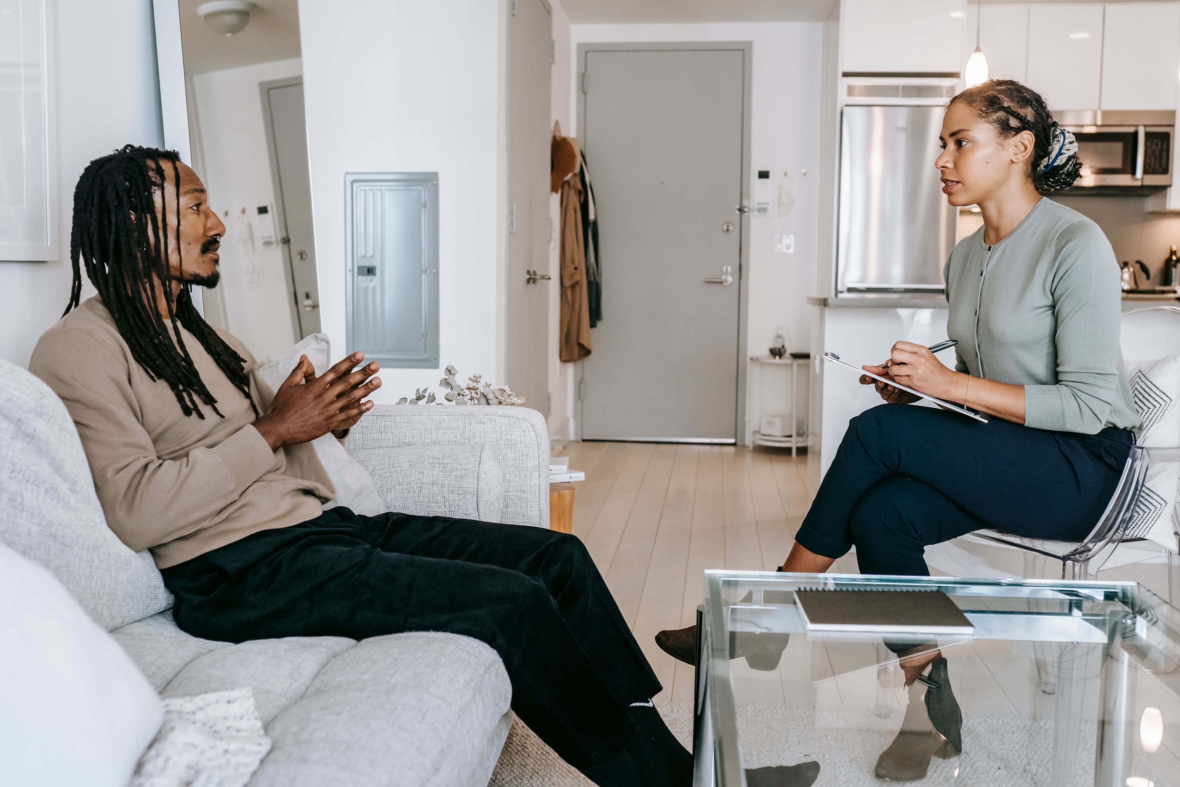 A Black therapist taking notes during a counseling session